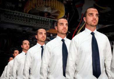Identical men with bar codes on a production line