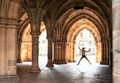 Girl jumping in cloisters of University of Glasgow