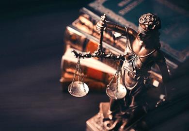 A justice statue next to some books