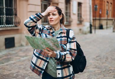A woman with a map looking lost, symbolising geography department closures