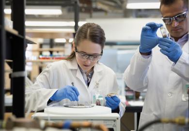Scientists using centrifuge in laboratory