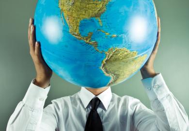 Man holding globe in front of face