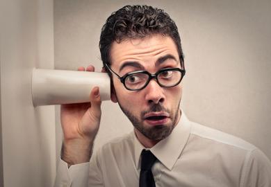 Man listening through wall with cup