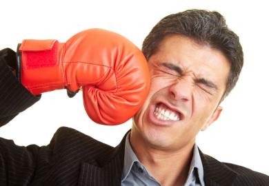 Man punching himself in face with boxing glove