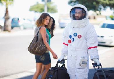 Man walking on street dressed as astronaut