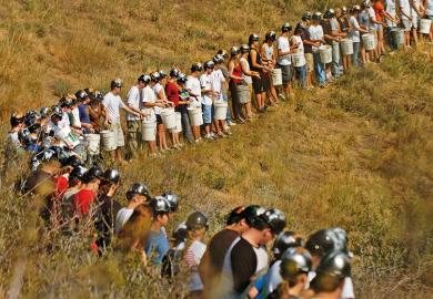 Miners standing in a line in a field