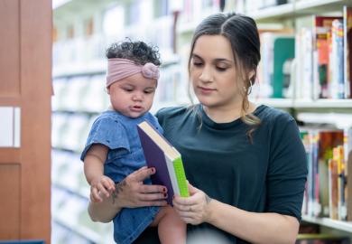 A mother with her daugher in a library, illustrating academic parenthood