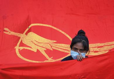 A protester stands with a Myanmar Student Union flag, 2021