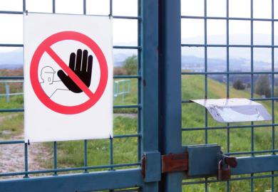 'No admission' sign on gated fence