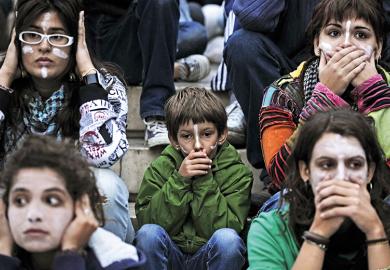 At an Occupy protest, people cover their mouths and ears