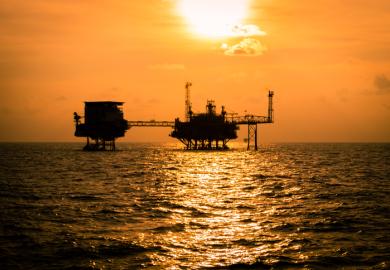 Sunset behind oil rigs, symbolising fossil fuel divestment