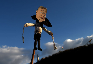 A puppet of Viktor Orban on a stick raised into the sky, symbolising his outsized influence