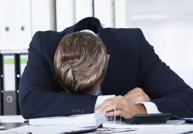 Overworked man slumped on desk