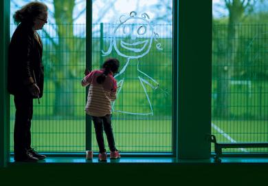 Child drawing in window