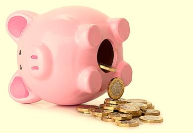 A piggy bank on its side with coins pouring our, illustrating pension unsustainability