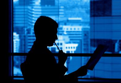 A reviewer in a corporate office ponders a manuscript