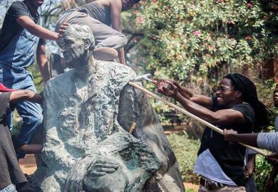 Protesters attacking statue