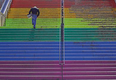 Person running up rainbow stairs to illustrate LGBTQ exam performance