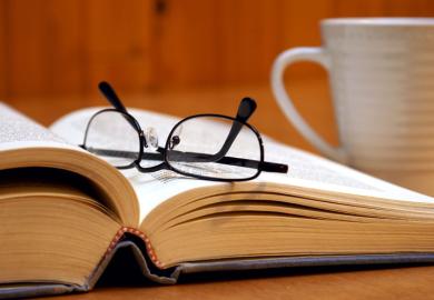 Reading glasses lying on open book