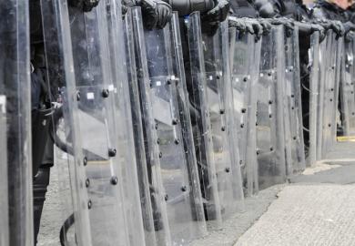 Police with riot shields illustrating the threat to higher education in Myanmar