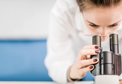 Scientist looking into microscope