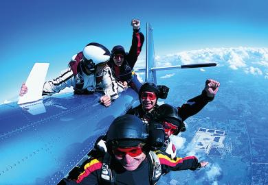 A group of skydivers clinging to a plane