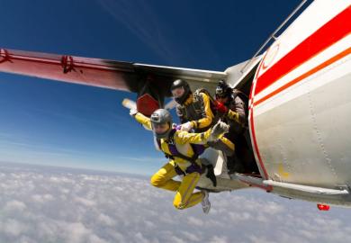 Three sky divers jumping out of a plane