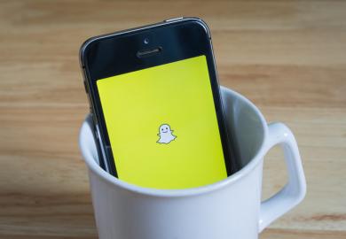A phone with the Snapchat ghost logo on its screen