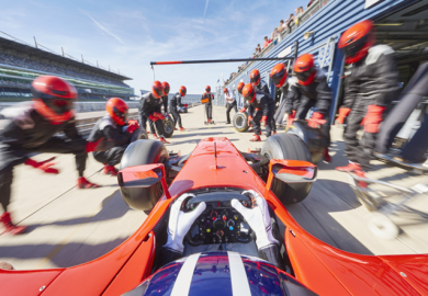 Technicians change the tyres of a racing car, symbolising support for spinouts