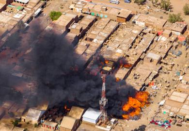 A building on fire in the Sudan war