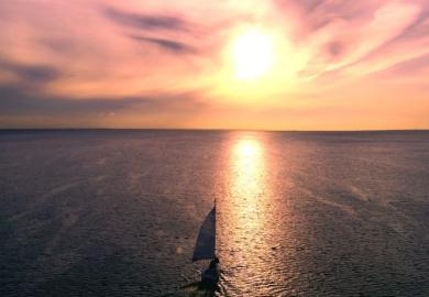 A yacht sailing into the sunset, illustrating retirement