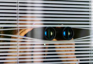  A woman peeking through blinds while holding binoculars, illustrating suspicion
