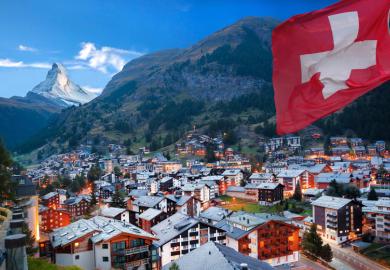 Swiss town with flag of Switzerland and Swiss Alps (Matterhorn) in background