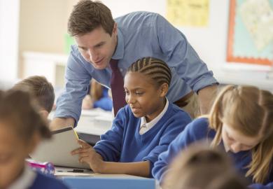 A schoolteacher helps his pupils