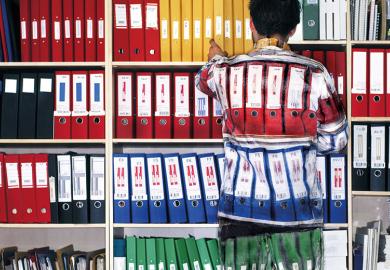 Man wearing camouflage suit matching shelves of folders