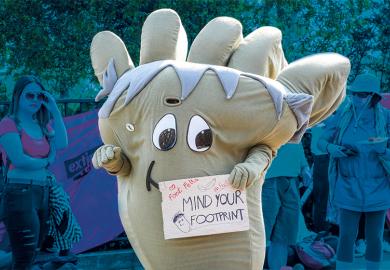 Climate protester dressed as a giant carbon footprint