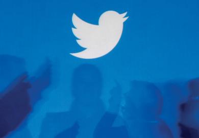 Twitter logo above silhouettes of people in discussion
