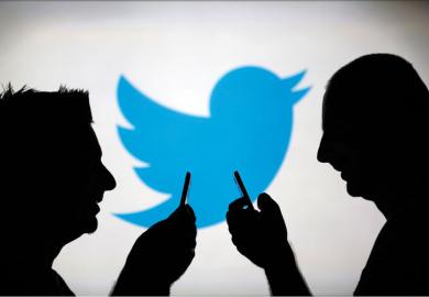 Men using smartphones against Twitter backdrop