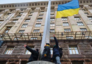 Activists hold Ukrainian flag during an action near the Kyiv City Council, demanding more money from the city budget for the Ukrainian armed forces