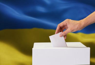 A ballot box in front of a Ukrainian flag