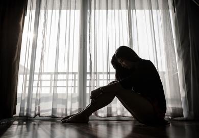 Unhappy young woman sitting alone