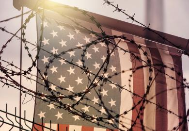 Barbed wire in front of the American flag, symbolising the crackdown on international students