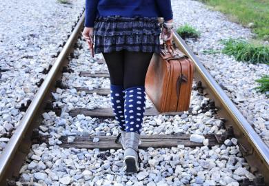 Woman walking alone on railway tracks