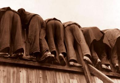 row of men bent over fence