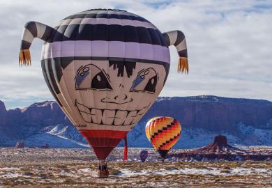 Hot air balloon flying low in Monument Valley Navajo Tribal Park in Arizonal as a metaphor for up, up and away