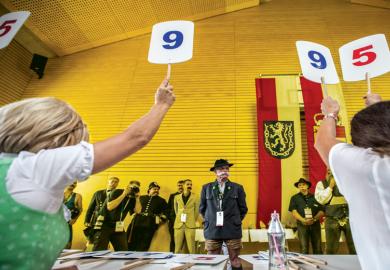 Contestants line up for judging panel who are holding up scores on boards as a metaphor for Discretion’ has no place in determining degree classifications