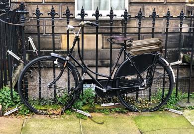 Old style bicycle with flat tyres chained up on fence railings with syringes around the wheels to illustrate Social research is being stymied by excessive ethical oversight
