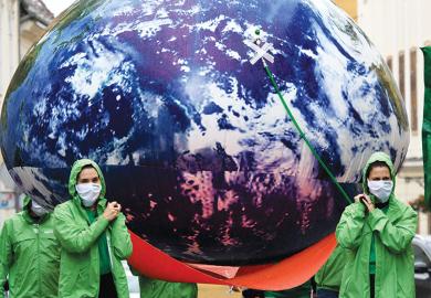 People carry giant balloon of planet Earth as a metaphor to the climate crisis is undeniably a global challenge