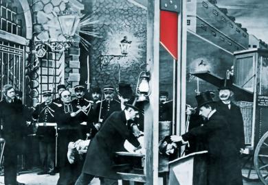 French postcard about 1900 showing a mock-up execution in a photographer's studio to illustrate Why should academics risk their livelihoods in contributing to books?