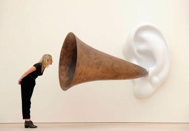 Woman leans in looking at an installation installation by US artist John Baldessari entitled ‘Beethoven’s Trumpet (With Ear)’ as a metaphor for universities will ‘listen to students’